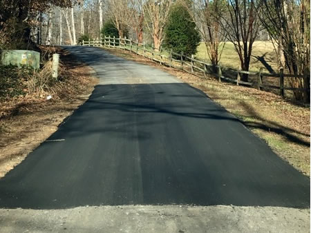Driveway repaired with patch of new asphalt